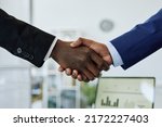 Close up of two business people shaking hands after successful partnership negotiation in office
