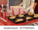 Small photo of Close-up f popcorn, chips and soda on counter selling for spectators in cinema