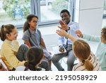 High angle view of teen high five with therapist while celebrating success in support group circle