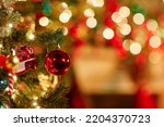 Close up background image of single red ornament on Christmas tree with twinkling lights, copy space