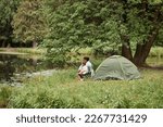 Wide angle view at mother and daughter camping together outdoors and fishing, copy space 