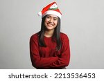 Happy young beautiful asian woman wearing christmas hat and red dress isolated on white background. christmas concept.