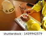 Small photo of Safe work practice top view of young trained administrator writing job hazards analysis working at height risk assessment safety control permit prior to start morning shift during shut down
