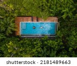 aerial drone view of swimming pool in the jungle of Krabi Thailand, aerial view with a drone above swimming pool in the jungle of Thailand. couple men and woman in pool from above