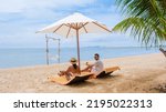 Small photo of Men and women on the beach are relaxing in a beach chair on a sunny day with a hammock in Pattaya Thailand Ban Amphur beach. couple walking on a tropical beach with palm trees and hammock