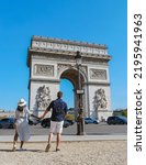 Small photo of Couple on a citytrip in Paris visiting Avenue des Champs Elysees Paris France Arc De Triomphe. Men and women visiting Arc de Triomphe in Paris