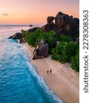 Small photo of Anse Source d'Argent, La Digue Seychelles, a young couple of Caucasian men and Asian women on a tropical beach during a luxury vacation in Anse Source d'Argent, La Digue Seychelles