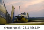 Small photo of The Air Tractor 502xp engine is finally shut down for the evening. It is framed by the larger 802 airplane. These hard working pilots and airplanes can spray thousands of acres in a day.