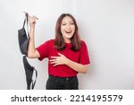 Woman smiling and holding a bra against white background. Concept of Breast cancer awareness and international no bra day celebration