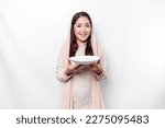 Small photo of An Asian Muslim woman is fasting and hungry and holding utensils cutlery while looking aside thinking about what to eat