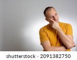 Small photo of Tariffed shocked troubled man, being shocked hearing bad news about relatives or friends. Very sad, depressed, alone, disappointed man resting his face on hands.