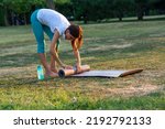 Small photo of Close-up of the grey tappet for outdoor fitness training. Training outdoors. Fitness mat, yoga, sports. Woman's hands touching her yoga mat in a grass field. Veiny, strong hands
