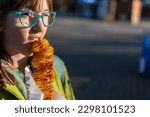 Small photo of Happy girl enjoy Yummy traditional Korean street food twister fries or twist potatoes on wooden skewers against street background. Korean street food, Potato twister. Hot Spicy Tornado Potato