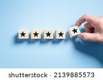 Small photo of Customer experience feedback rate satisfaction experience five star rating placing wooden blocks on blue background