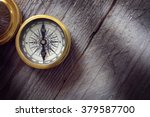 Antique golden compass on wood background concept for direction, travel, guidance or assistance