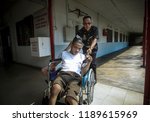 Small photo of SELANGOR, MALAYSIA - 27 SEPTEMBER 2018: Malaysian police help disabled people use wheelchairs to move around. Using under exposure.