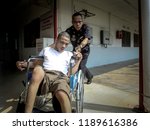Small photo of SELANGOR, MALAYSIA - 27 SEPTEMBER 2018: Malaysian police help disabled people use wheelchairs to move around.