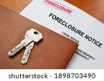 Small photo of A foreclosure Notice And House Keys on a table with space for text