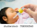 Small photo of Nasal instillation for baby. Nasal instillation of medication. Nose drops. Ear instillation for baby. Ear instillation of medication. Ear drops. Close-up mother's hand holding dropper.