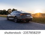 Small photo of Riga, Latvia 5 September 2023 Audi A5 Sportback quattro TFSI district green color, facelift or lci model update. RS version exterior. Stands on countryside road, background sunset mood. Close up view