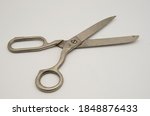 Old metal tailor scissors on a white background.