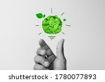 Corporate Social Responsibility (CSR), eco-friendly business concepts with businessman hand holding crumpled green paper light bulb
