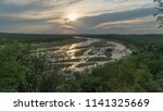 The Sun Sets Behind A River In...