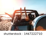 Beautiful girls and young people traveling with jeep car in a sunset in a beach landscape