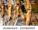 Wooden bows set up in a row at a shooting gallery at the fair, with a shallow depth of focus