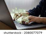 Small photo of Young man sitting using a computer to analyze ESG, environment, conservation, society, governance, close to the computer screen in business investment strategy concept.