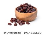 Raisins in wooden bowl isolated on white background.