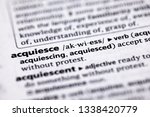 Small photo of Blurred close up to the partial dictionary definition of Acquiesce