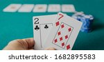Small photo of Bad poker gamble or unlucky hand concept with player going all in with 2 and 7 (two and seven) offsuit also called unsuited, considered the worst hand in poker preflop (before the flop is revealed)