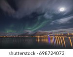 Sortland bridge at night with northern lights above the hills and mountains by the sea