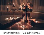 Hands man and woman holding glasses of wine having romantic candlelight dinner at table at home. Hands man and woman holding glass of wine. Concept of Valentine's day or Candlelight date at night.