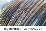 Small photo of Close-up of rust wire coils in metal steel industrial yard or storage area, steel wire coils or wire rod for wires industry production, concrete usage and building construction