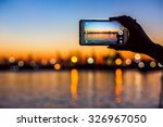 Wonderful sunset over sea harbor, tourist taking a picture of the seaport