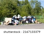 Small photo of Krasnoyarsk, Russia - June 13, 2022: a huge pile of household rubbish near dumpsters full with garbage. Boorish attitude of people towards ecology. Environmental disaster in the world of consumption