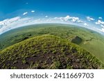 Fisheye shot of green grassland with volcanic craters in the steppe of Mongolia, Central Asia from an elevated view