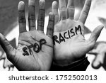 Close-up of the raised hands of two men of different ethnicity with the slogan 