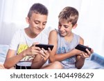 Cute  little boys, brothers playing online games on their smart phones. Modern child activity