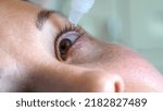 Small photo of The eyes of a young woman. At the doctor. Instillation into the eyes. Treatment of eye diseases. Cosmetology. Ophthalmologist. Face with fair skin. Close-up. Macro.