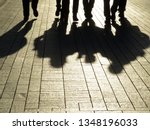 Silhouettes and shadows of people on the street. Crowd walking down on sidewalk, concept of strangers, crime, mafia, society, street gang