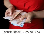 Small photo of Russian rubles in female hands, cash pay, salary, inflation or savings concept. Woman in red dress counting paper currency of Russia