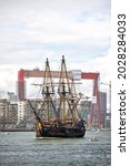 Small photo of Goteborg, Sweden - Aug 16, 2021: Swedish replica East Indiaman Ship Gotheborg leaves Goteborg while passing the famous gantry crane of Eriksberg. Original ship sank 1745 outside Goteborg.