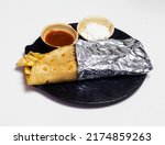 Small photo of Franky roll wrap in aluminum foil, also known as Kolkata style spring rolls, vegetarian Indian food, Roll wrap Franky food