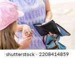 Small photo of Anonymous mother giving her child money, hands closeup, wallet, receiving pocket money, giving kids money, monthly allowance simple concept. Children, small family finance management, people lifestyle