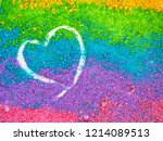 Small photo of bright colorful background made of colored sand with drown heart form. pink lelac green and yellow colors with copy space