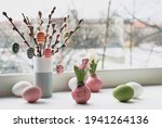 Easter decorations on windowsill, panoramic image. Wooden painted eggs on pussy willow. Hyacinth flowers with bulbs in pink wax. Window, view over town. Romantic indoor setup. Happy Easter