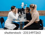 Small photo of Slit lamp diagnosis and examination of the cornea and eyes of child girl. Pediatric ophthalmologist with slit lamp examines and consults mother with her child